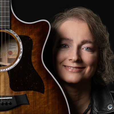 Bild von Julia Wörlein die mit der Gitarre kuschelt